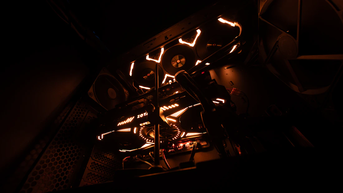 Custom gaming PC internals lit with orange neon and liquid cooling